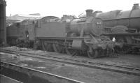 Collett 2-6-2T no 4165 in the yard at Wolverhampton's Stafford Road shed in August 1962, looking slightly intimidated by King class 4-6-0 no 6012 <I>King Edward VI</I> standing alongside. The tank engine survived for another 3 years, although the 'King' was withdrawn one month after the photograph was taken.<br><br>[K A Gray 15/08/1962]