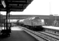 Bescot class 47 no 47386 brings a train of 100t oil tanks under Coronation Bridge and north through Rotherham Masborough station in May 1981. The station finally closed in October 1988.<br><br>[John Furnevel 04/05/1981]