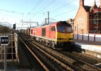 Although it was a sunny afternoon, the temperature at Wigan North Western on 11 March was around freezing when the windchill factor was taken into account. Here DBS 60011 heads south through the station with the 6G42 Carlisle to Warrington gypsum boxes. <br><br>[John McIntyre 11/03/2013]
