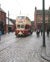 On a suitably dreich day, with wet cobbles glinting, passengers alight at the Beamish Town stop. A department store very familiar during the photographer's childhood is advertised on the front of the double deck tram.<br><br>[Brian Taylor 02/04/2013]