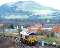 EWS 66111 running light engine takes the line towards Millerhill Yard at Niddrie West Junction in January 2003. Arthur's Seat dominates the background. <br><br>[John Furnevel 12/01/2003]