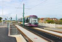 The quality of finish on the new Blackpool and Fleetwood tram stops is a complete contrast to the old system. <I>Flexity</I> 013 slows for the Rossall School stop on a service from Fleetwood. [See image 32523] for the same location in 2011 (and earlier).  <br><br>[Mark Bartlett 10/08/2013]