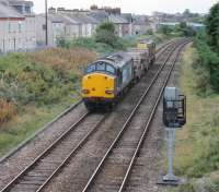 DRS 20303 and 37605 pass the site of Morecambe Euston Rd, the town's LNWR station, as they slow to a stop prior to reversing. 37605 will then head down the Heysham branch with two empty flasks for the nuclear power stations. <br><br>[Mark Bartlett 26/09/2013]