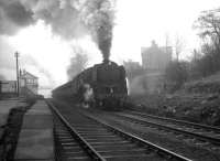 A trainload of iron ore on its way from Tyne Dock to Consett photographed passing through Beamish station on a February morning in 1964. Hard working 9F 2-10-0 no 92097 heads the procession, while bringing up the rear is WD 2-8-0 no 90434, having joined the train at South Pelaw. <br><br>[K A Gray 15/02/1964]