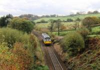 Coasting downhill through Lancashire moorland scenery in October 2013, a Northern Pacer approaches the level crossing and closed station at Turton & Edgeworth. 142036 is on a Blackburn to Manchester Victoria service. This line, singled in the 1970s, was redoubled around Darwen in 2015 for the planned circular services to Burnley using the reinstated Todmorden chord. <br><br>[Mark Bartlett 26/10/2013]