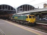 Freightliner 66554 runs northbound through Newcastle Central Station shortly after mid-day on 28 November with a rake of empty coal wagons.<br><br>[David Pesterfield 28/11/2013]