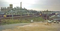 A panorama of Colchester station on a dismal 10th January 1976. The former Essex Hall Hospital (demolished 1989) occupies the background to the left while in the right foreground is the rough and ready overspill car park. Platform 2 in the station is hosting an unusual visitor in the form of a Class 33 at the head of a football special. It has just arrived with Crystal Palace fans who are about to transfer to the buses on the right and head for Colchester United's ground at Layer Road. The visitors went away happy despite the weather, having won three nil.<br><br>[Mark Dufton 10/01/1976]