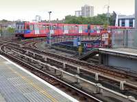 A DLR train curves away from West India Quay towards Stratford on 28 July, while another from either Becton or Greenwich Arsenal passes below.<br><br>[Bill Roberton 28/07/2014]