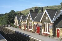 The up side station buildings at Settle, seen from the footbridge on the warm and sunny evening of 17 July 2014. The far building is the former stationmaster's house - this one  located rather closer to the railway than most of the other such houses on the S&C.<br><br>[Bill Jamieson 17/07/2014]