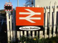 The large and rather unusual station sign by the level crossing at Dolau Station, on the Heart of Wales line, mounted on the well worn fence at the rear of the disused northbound platform.  <br><br>[David Pesterfield 10/04/2012]