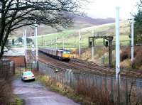 An up Virgin WCML express passing the site of Abington station on 7 December 2002, with Station Road curving away bottom left towards the village. The modern looking buildings and the sidings beyond are used primarily in connection with PW/maintenance activity. [See image 6252]<br><br>[John Furnevel 07/12/2002]