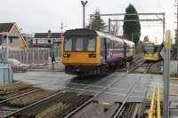 <I>On parallel lines.</I> Two services, both heading for Manchester Piccadilly, meet at Navigation Road on 13 January. Northern 142047, from Chester, runs over the level crossing, closely followed by Metrolink 3052. The Pacer will turn right at Deansgate Jnction to run via Northenden and Stockport while the tram service continues along the old MSJ&A route through Stretford. <br><br>[Mark Bartlett 13/01/2015]