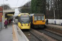 Two services for Manchester Piccadilly meet at Navigation Road. Pacer 142047 will travel via Stockport with three intermediate stops. Tram 3052 has 11 intermediate stops but a more direct route and both services will reach Piccadilly in just under thirty minutes.  <br><br>[Mark Bartlett 13/01/2015]
