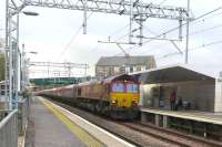 The gradient is evident along the line of wagons as 66066 attracts attention from waiting passengers at Cumbernauld station as it passes with a train of coal from Hunterston to Longannet on 5 March.  With more than 2000 tonnes on the drawbar it is unsurprising that the loco could be heard before it appeared.<br><br>[Malcolm Chattwood 05/03/2015]