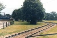 Looking over the curved track towards the former BOCM Unitrition grain processing plant at Selby in 2002, with the site's Unimog road rail vehicle over on the left at the head of a rake of eight loaded 2 axle high capacity wagons it has propelled from the overhead loading facility behind the camera. [See image 50763]<br><br>[David Pesterfield 14/08/2002]