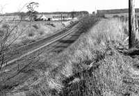 Looking east along the Winchburgh Loop towards Dalmeny Junction in April 1972, with Winchburgh Junction behind the camera and the trackbed of Myre Siding to the right of the running lines. The few cottages in the middle distance constitute Myre itself. [Ref query 7596]<br><br>[Bill Jamieson /04/1972]