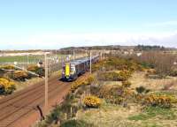 The 10.04 Glasgow Central to Ayr passing through the site of Monkton Station on 16 April 2015. The Prestwick Airport fuel discharge siding is on the left. [See image 14194]<br><br>[Colin Miller 16/04/2015]