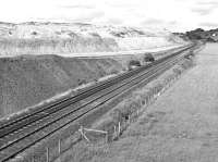 Located near Midcalder Junction, the large shale bing associated with the Oakbank Oil Works was often referred to as 'Contentibus Bing'. In June 1984 it was in the process of being reclaimed for motorway construction with rail being the means of delivery. The entrance to the siding can just be made out in the right background.<br><br>[Bill Roberton 23/06/1984]