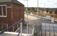 The new pedestrian entrance to Newtongrange station giving access from the overbridge on the A7 Murderdean Road. The building on the left was part of the rail served Dean Oil Works which once occupied the station site. Photographed through security fencing on 17 July 2015. [See image 51987]<br><br>[John Furnevel 17/07/2015]
