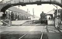 A Glasgow St Enoch - Largs train calls at Stevenston on 4 April 1959. The locomotive simmering gently at the platform is Fowler 2P 4-4-0 no 40667, with only 6 months to go before its eventual withdrawal from Ardrossan shed. View is east over Station Road level crossing.<br><br>[G H Robin collection by courtesy of the Mitchell Library, Glasgow 04/04/1959]