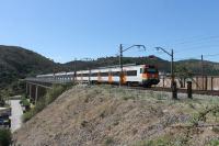 Two RENFE Class 447 EMUs have just left Colera station and rumble onto the viaduct heading south. The bridge, high above the town itself, is one where the rails run across the open girders but there is no decking.<br><br>[Mark Bartlett 19/09/2015]