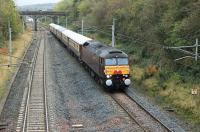The <I>Entente Cordiale</I>, a private charter from Carnforth to Spean Bridge, runs through Clifton and Lowther on 23rd October 2015. The train comprised West Coast 57601, complete with headboard and Anglo-French bunting, and six gleaming Pullman coaches. Photographed from the bridge at Grid Reference NY541257. The old station, closed in 1938, lay just beyond the three arch bridge.<br><br>[Mark Bartlett 23/10/2015]