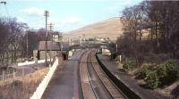 The view north over Abington station in March 1966, some 14 months after closure. Photographed from the bridge carrying Station Road, which continues towards the village on the left. The station building has since been replaced by a maintenance compound and the platforms by passing loops. [See image 5602]<br><br>[John Robin 25/03/1966]