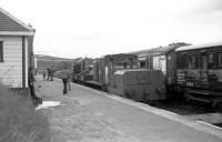 Looking along the platform at Boat of Garten on 10 June 1973 with Simplex 4w DM shunter and Hudswell Clarke 0-4-0 DM shunters with CR hand crane on the northbound platform. On the other side are ex NBR coach converted to use as a dormitory coach and former Gresley designed 1st class sleeping car.<br><br>[John McIntyre 10/06/1973]