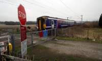 Northbound service from Queen Street to Oban, Fort William and Mallaig passes Geilston Level Crossing and its ample warning signage.<br><br>[Ewan Crawford 18/03/2016]