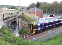 A Tweedbank - Edinburgh train about to restart from the platform at Newtongrange on 1 May 2016 before passing below the bridge carrying the A7.<br><br>[John Furnevel 01/05/2016]