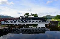 Black 5 No.45407 is reflected in the Caledonian Canal as it crosses the swing bridge at Banavie at the start of the journey to Mallaig.<br><br>[John Gray 02/08/2016]