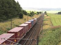 With Carstairs East Junction in the distance, a consignment of ECS Eurocontainers passes below the A70 road bridge on the Edinburgh line on 31 August 2016. The train is the 0422 Tees Dock – Mossend Euroterminal.    <br><br>[John Furnevel 31/08/2016]