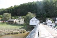 A view looking back over the wooden toll bridge at Penmaenpool to the south bank of the estuary, and the <I>bird hide</I> signal box, on 19th September 2016. The old station lies just to the right of the toll booth, which was once adjacent to a level crossing. <br><br>[Mark Bartlett 19/09/2016]