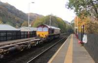 DB 66170 rolls eastwards through Walsden on 31st October 2016 with a freight carrying containers of waste from Knowsley Freight Terminal on the Kirkby Branch to Wilton in Teesside. Contrary to appearances the long train was well loaded. <br><br>[Mark Bartlett 31/10/2016]