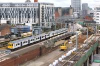 A Liverpool to Manchester Victoria stopping service passes Salford Central on the newly re-aligned track through what may become platform 3. Until a few weeks ago these lines between Ordsall Jct and Deal St Jct ran to the right where the digger is located.<br><br>[John McIntyre 19/05/2017]