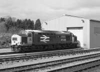 EE Type 3 37418, stranded by the Ness Viaduct collapse, sits outside the temporary Muir of Ord shed in 1990. After a long mainline career this loco went into preservation on the East Lancashire Railway.<br>
<br><br>[Bill Roberton //1990]