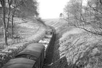 View west from the road bridge at Gordon looking towards Earlston on a fine day during the Easter holiday in 1965. The branch pick up goods is on its way back from Greenlaw to St Boswells, with the locomotive propelling two wagons to be deposited at Earlston sawmill on the way home. [See image 22900]<br><br>[Bruce McCartney //1965]