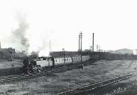 Sunlit Fairburn tank 42243 with a Glasgow bound train at Ardrossan North on 5 July 1959. The Shell refinery stands in the right background. The line to the right formerly served the engine shed.<br><br>[G H Robin collection by courtesy of the Mitchell Library, Glasgow 05/07/1959]