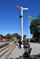 The Station Master (Stinsen) sets the signal on the platform at Hesselby to <I> line clear </I>. This heritage narrow gauge railway recreates some of the aspects of railway operation on the Swedish Baltic island. Gotland had several 891mm gauge (3 Swedish feet) lines which first opened at the end of the nineteenth century/early twentieth century. Those that remained in operation were taken over by SJ in the 1940s but all were subsequently closed by 1960.<br><br>[Charlie Niven 05/07/2017]
