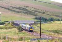 An Edinburgh bound train on the Borders Railway passes below a farm bridge just north of Heriot on the approach to Falahill. The train has approximately 5 miles to run to its next scheduled stop at Gorebridge.<br><br>[John Furnevel 30/07/2017]