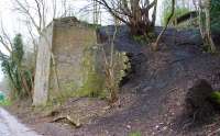 Remains of the northern abutment of the bridge that once carried the spoil tramway across the access road on its climb up to the tipping point on the south bing. The south portal of the sealed tramway tunnel is visible top right.<br><br>[John Furnevel 10/04/2016]