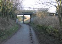 High Harrington station on the Cleator & Workington Junction Railway, seen in March 2018. This view looks towards Distington along the established trackbed cycle path. The remains of the Workington platform, which last saw passengers in 1931, can be seen on the right. Goods trains continued to pass through until 1964. The central bridge pier is a later addition supporting the heavy road traffic that passes over today. [Ref query 14 March 2018] <br><br>[Mark Bartlett 09/03/2018]