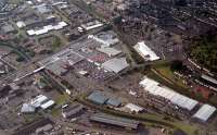 Aerial view of the former Singer Workers Platforms (centre, now the Clydebank Shopping Centre). Note trains passing to right.<br><br>[Ewan Crawford //]