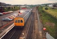 Glasgow-Cumbernauld shuttle leaves to swap sides at Cumbernauld. A freight waits (distant). Train, signalbox and signals all gone.<br><br>[Ewan Crawford //1987]