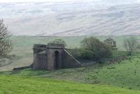 The eastern abutment of Belah Viaduct stands on a remote hillside in the Pennines on the former South Durham & Lancashire Union Railway line over Stainmore.  Photographed from the other side of the valley in May 2006. The shell of the old signal box still stands. <br><br>[John Furnevel 11/05/2006]