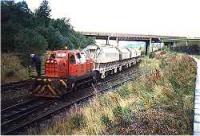 Limestone train (white ladies) being pulled by an industrial locomotive past the Ravenscraig gasometers.<br><br>[Ewan Crawford //]