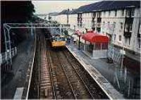 View looking west at Woodhall station. Class 303 entering station.<br><br>[Ewan Crawford //]