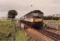 Class 47 hauled passenger train running south past Dalwhinnie Distillery.<br><br>[Ewan Crawford //]