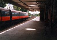 Looking west at a Class 303 from beside the former station building at Neilston.<br><br>[Ewan Crawford //1987]