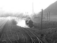 View east from the footbridge at Niddrie West Junction towards Niddrie South Junction on a misty November morning in 1970 as NCB Lothians North no 25 (AB 2358 of 1954) returns from the exchange sidings to the shed at Newcraighall (Klondyke) colliery [see image 31752]. All signs of the sidings and the colliery itself are long gone, with the land to the right now occupied by the Fort Kinnaird retail park. <br><br>[John Furnevel 30/11/1970]